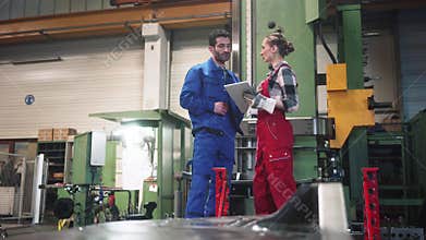 Woman and man manufacturing worker in discussion