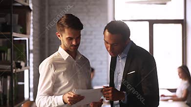 Multiracial coworkers talking discussing financial report paperwork during working day
