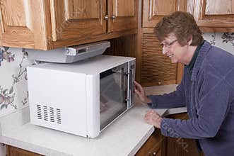 Senior Mature Woman Cooking Microwave Oven Kitchen