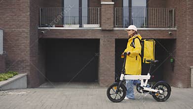 Happy Attractive Caucasian Woman Courier Walking With Bike In the Building, Delivering. Fast Delivery. Postal Lady