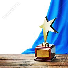 Star award wooden table and on the background of blue curtain
