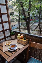 Morning setup on wooden table at balcony for morning relaxation with books, cup of tea, teapot, organic honey, green tea leaves