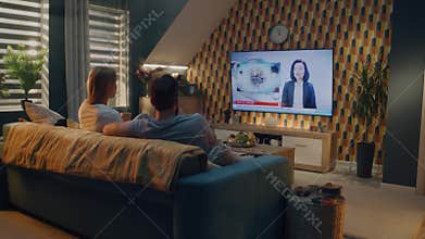 Couple watching TV news about water pollution