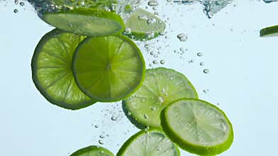 Tropical sliced lime dropped water in white background closeup. Citrus splashing