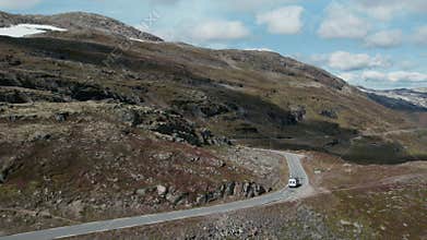 Cinematic aerial shot of van on epic norway road