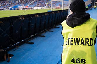Steward next to the football pitch