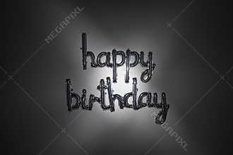 Silver happy birthday balloon lettering with dark, moody light. Foil letters on horizontal background.
