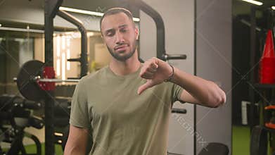 Sad upset dissatisfied loser bodybuilder African American man showing thumb down bad result unmotivated disagree dislike