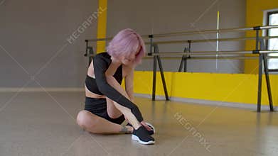 Upset sad lovely woman dancer suffering from pain and massaging injured leg