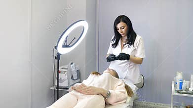 Beauty injections. Lip augmentation procedure. Beautician prepares lips for lip augmentation. The cosmetologist in