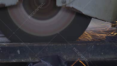 Worker using metal cutting circular saw blade in constuction site