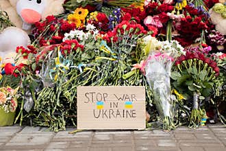 Toys and flowers lie at a trolleybus stop next to a house blown up by a Russian rocket on Pobeda in the city of Dnepr in Ukraine
