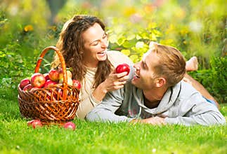 Couple Relaxing on the Grass and Eating Apples