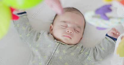 Sleeping newborn baby boy lying on white cozy bed alone at home. Top View.