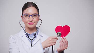Female doctor cardiologist showing heart symbol