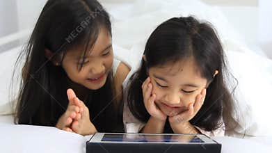 Little Asian girls enjoy with tablet