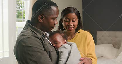 Loving Black Parents Adore Their Sleeping Newborn Baby in Bedroom: A Tender Family Moment at Home
