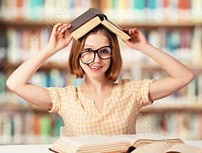 Tired funny girl student with glasses reading books