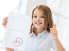 Smiling little student girl with test and A grade