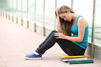 Beautiful teenager girl depressed sitting on the floor outdoor