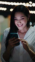 Vertical Video. Pretty Lady Winning the Money Online while Standing Outside.