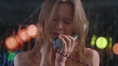 Upset woman in a phone booth talking on the phone