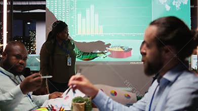 Diverse group of corporate associates look into project timelines and agenda