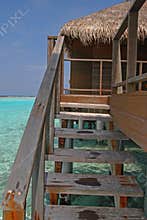 Blue sky turquoise water convenient direct access to your Private Overwater Villa at a tropical resort island, Maldives
