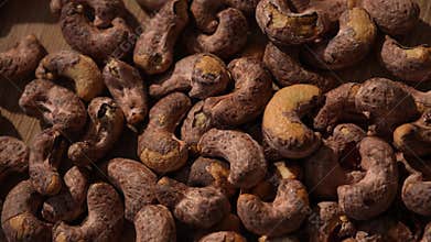 Dolly shot over raw cashew nuts on wooden surface