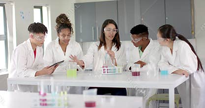 Diverse students collaborate on science experiment at high school