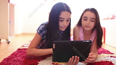 Two happy teenage girls using tablet computer