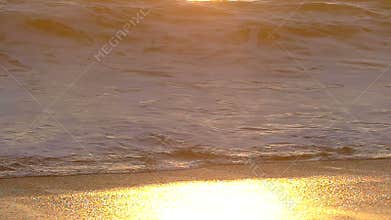 A Wave Crashing on The Beach at Sunset in Slow Motion