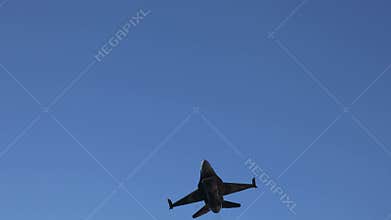 The F16 fighter performs aerobatics over the sea against the background of mountains