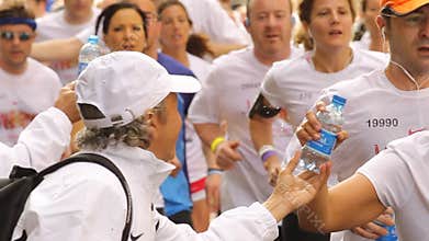 Runners taking water bottle