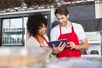Colleagues in red apron using tablet