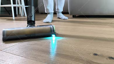 Close view shows rotating brush of vacuum cleaner removing dust