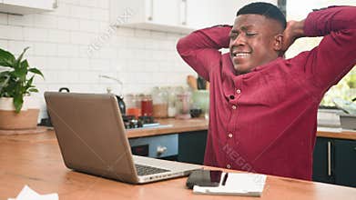 Happy African Man Stretching and Relaxing While Working From Home on Laptop in Kitchen