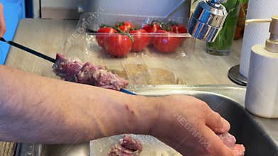 Preparing Marinated Lamb Shashlik on Metal Skewers.