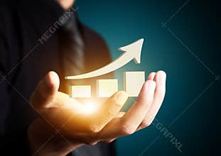 Hand holding a rising arrow,business growth.