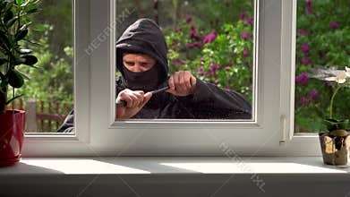 Burglar breaks into a house through the window