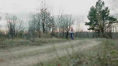 Young beautiful woman riding a bicycle in a park. Active people. Outdoors