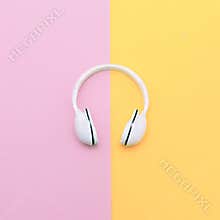 Fashion white headphones on vanilla background