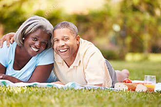 Senior Couple Having Picnic In Garden