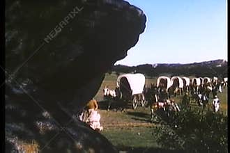 Montage of covered wagons and settlers traveling cross country