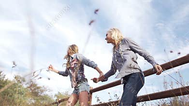 Beautiful young women jumping across fence running