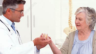 Doctor showing patient how to exercise injured hand