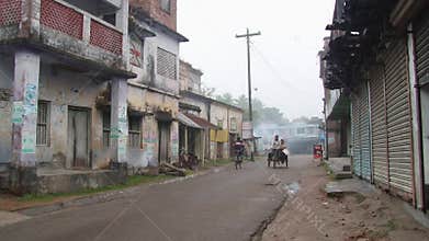 People ride bicycles by the street on a cold foggy morning in Puthia, Bangladesh.