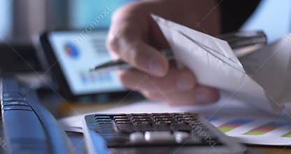 Accountant business person working on tax return forms at desk on calculator