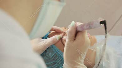 Cosmetologist applying permanent make up on eyebrows- eyebrow tattoo