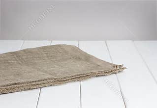 White wooden table with tablecloth, light background for product montage